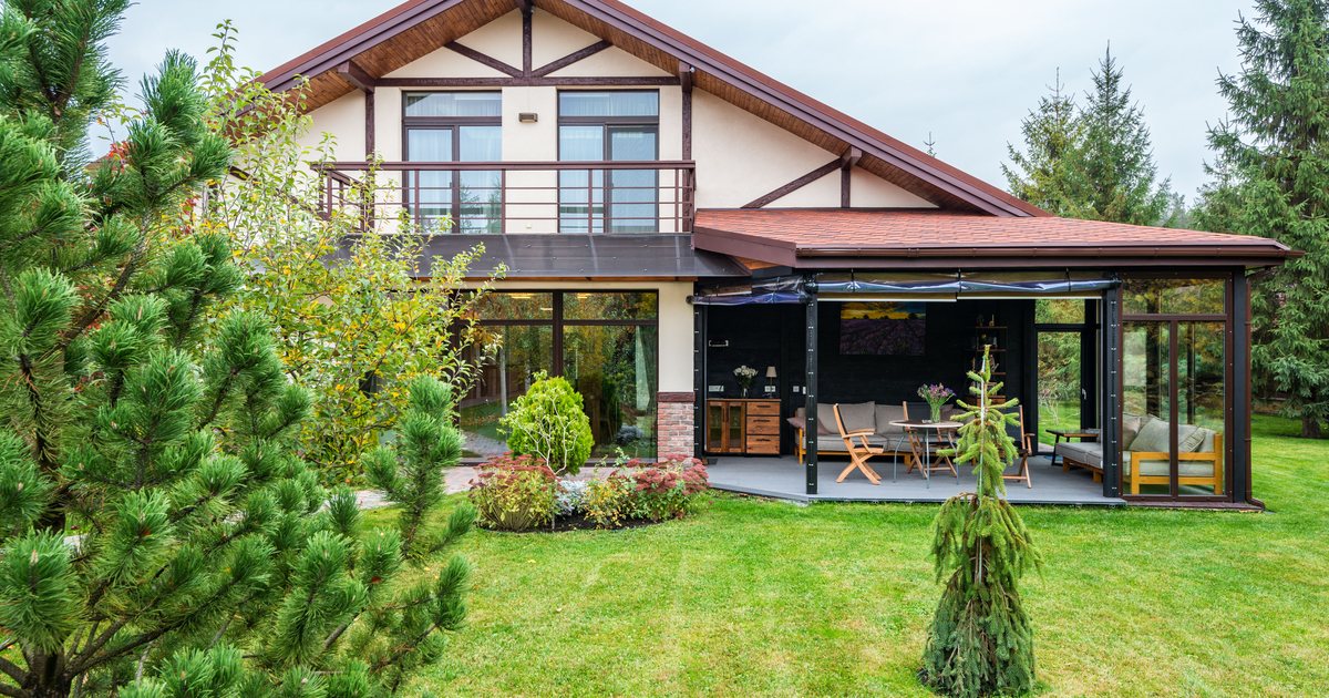 A house backyard with a wide, open green lawn