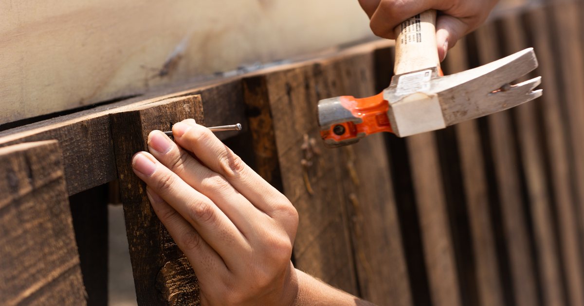 A hammer driving a nail into wood in close-up